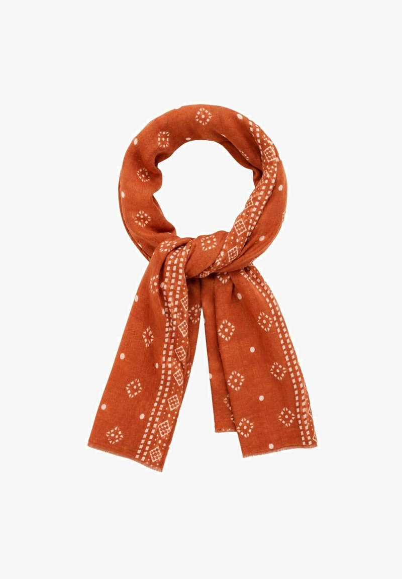 Écharpe orange brûlé avec des motifs géométriques et ponctués blancs, nouée de façon lâche et présentée sur fond blanc.