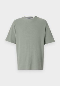 Olivgrön t-shirt med kort ärm, rund halsringning, tillverkad av mjukt strukturerat material. Enkel design utan synliga mönster eller dekorationer.