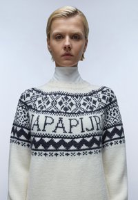 Gebreide trui met een crèmekleurige basis en zwarte fair isle patronen en logo. Hoogwaardige nekontwerp met gestructureerde mouwen en fijne details.