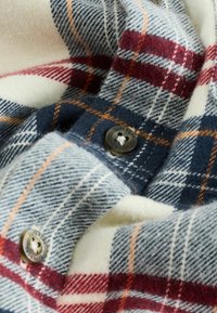 Ruudullinen flanellipaita tummansinisessä, valkoisessa ja punaisessa värissä, jonka pehmeä tekstuuri ja pyöreä "Superdry" -metallinappikoriste tekevät siitä ainutlaatuisen.