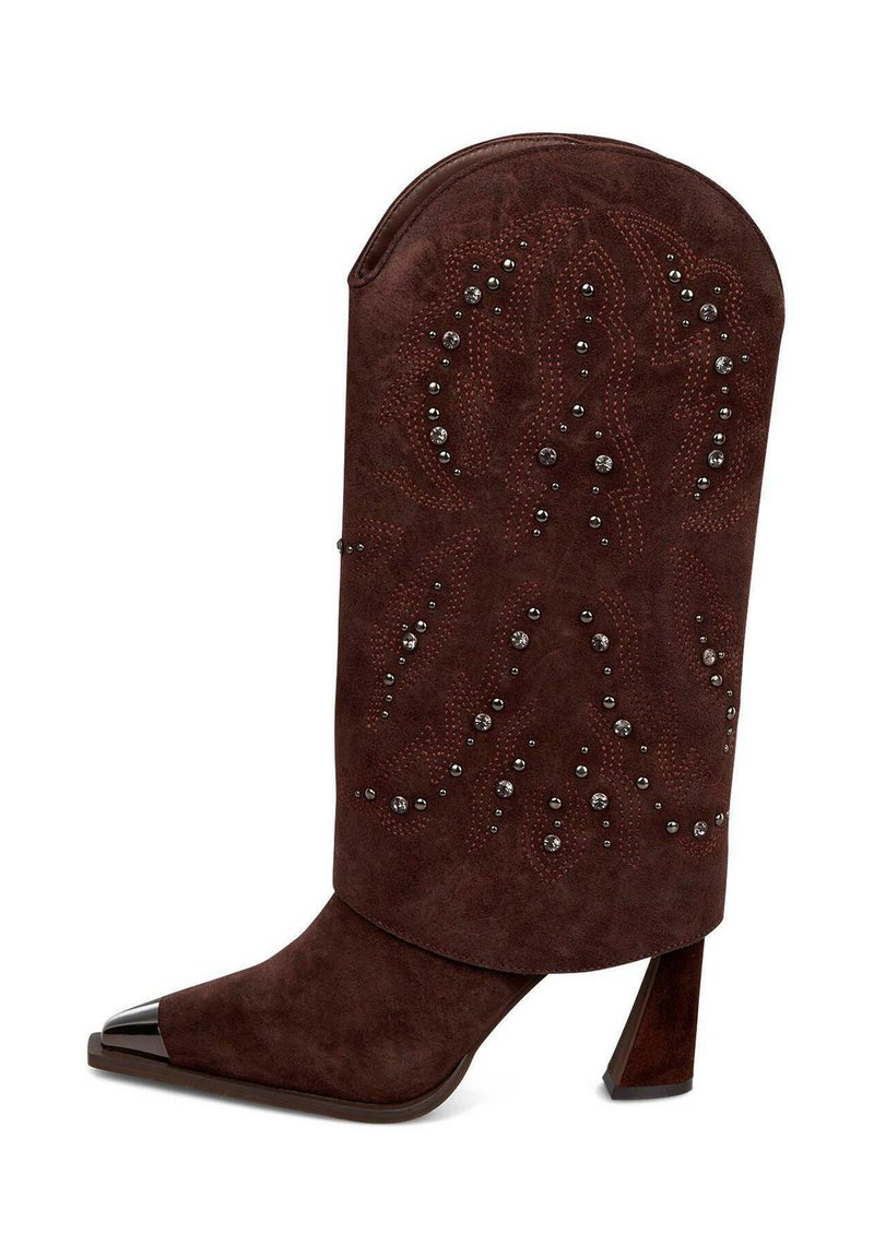 Brązowy zamszowy but z wydłużonym, zaokrąglonym mankietem i spiczastym czubkiem. Posiada dekoracyjne przeszycia i ćwieki. Masywna pięta z metalowym akcentem.