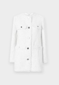 Chaqueta de tweed blanca con un diseño estructurado, que cuenta con dos bolsillos en el pecho, botones en tono plateado y un acabado texturizado.