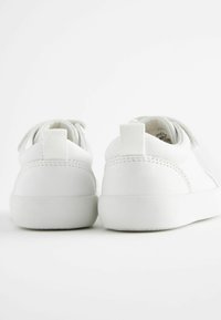 Hvide sneakers med en glat syntetisk overdel, rund tå, forstærket hælflap og en flad gummisål. Enkle syninger ved sømmene.