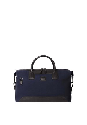 Navy fabric duffel bag with black leather accents, dual handles, zipper closure, and a detachable shoulder strap. Features logo tag and side loop.
