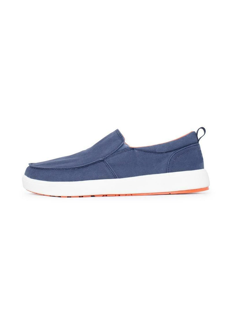 Zapatillas de tela azul marino tipo slip-on, con suela de goma blanca y acentos naranjas. Textura suave con punta redondeada y costuras mínimas.