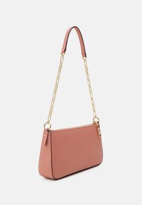 Suuri pörröinen vaaleanpunainen käsilaukku, jossa on kultaketju ja vetoketjukiinnitys, sivussa pieni kultainen logokoriste.