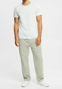 Stribet lyseblå og hvid t-shirt med rund halsudskæring parret med strukturerede lysegrønne kordfløjl-bukser og hvide sneakers.