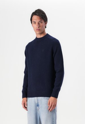 Navy blue knitted sweater with a crew neckline, ribbed cuffs and hem, featuring a subtle logo on the front, made from soft material.
