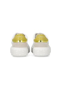 Zapatillas blancas con una suela gruesa y texturizada, con un acento de cuero amarillo y una franja dorada. Nombre de la marca "PINKO" mostrado en el talón.