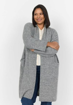 Svetle šedý cardigan, vyrobený z měkkého pleteného materiálu, má volný střih, dlouhé rukávy, hluboké přední kapsy a otevřený design.