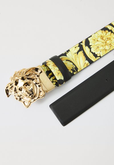 Schwarzer Ledergürtel mit einer goldenen Löwenkopf-Schnalle, ausgestattet mit einem gelben Blumenmuster auf dem Riemen, glatter Textur und rechteckigem Lederende.