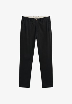 Pantalon noir à jambe droite avec fermeture à boutons et à glissière, passants pour ceinture et poches latérales, posé à plat sur un fond blanc.