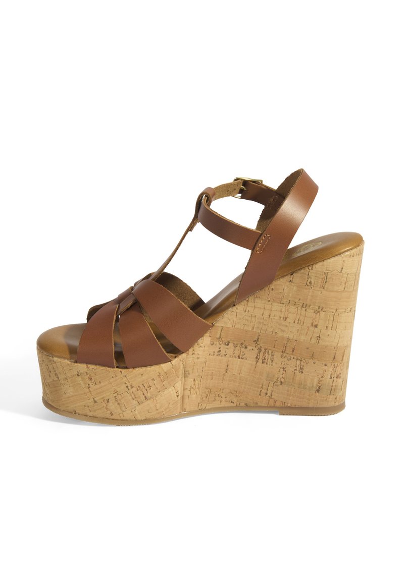 Sandale marron à talon compensé avec une semelle en liège, dotée de larges straps croisés et d'une bride de cheville réglable. Texture lisse, design de plateforme surélevée.