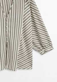 Blouse à rayures verticales beige et marron avec col en V, boutonnage sur le devant et manches trois-quarts bouffantes avec poignets.