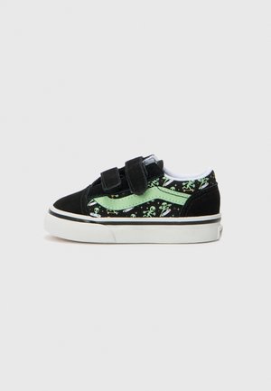 Basket enfant noire et verte avec motifs d’extraterrestres et de vaisseaux spatiaux, deux bandes velcro, et semelle en caoutchouc blanche sur fond uni.