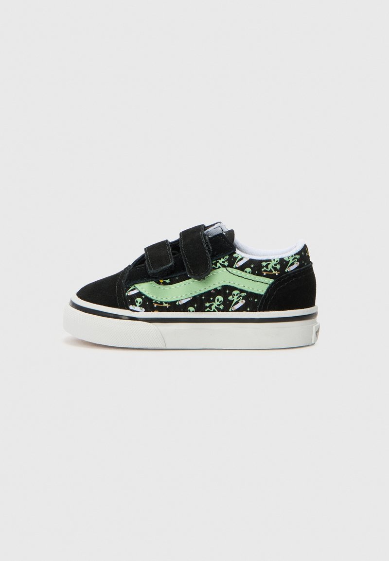 Basket enfant noire et verte avec motifs d’extraterrestres et de vaisseaux spatiaux, deux bandes velcro, et semelle en caoutchouc blanche sur fond uni.
