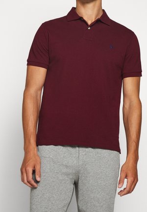 Bordeaux poloshirt met een klassieke kraag, korte mouwen en een klein blauw logo. Gemaakt van een gladde, lichtgewicht stof.