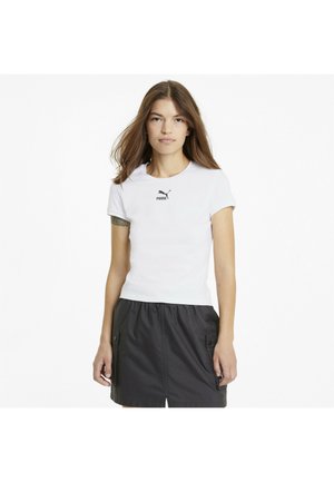 Camiseta blanca de manga corta con cuello redondo y logo de Puma negro, combinada con una falda negra con cordón y bolsillos laterales.