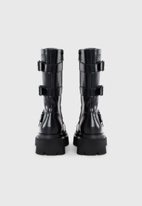 Black leather combat boots feature a chunky sole, three buckled straps, and a smooth finish. Designed for durability and style.
