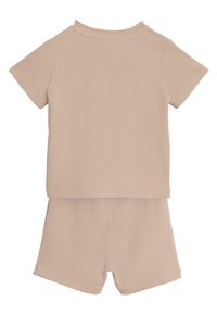 Conjunto beige de dos piezas que incluye una camiseta de manga corta con textura y pantalones cortos a juego. El material presenta un patrón de tejido tipo gofre.