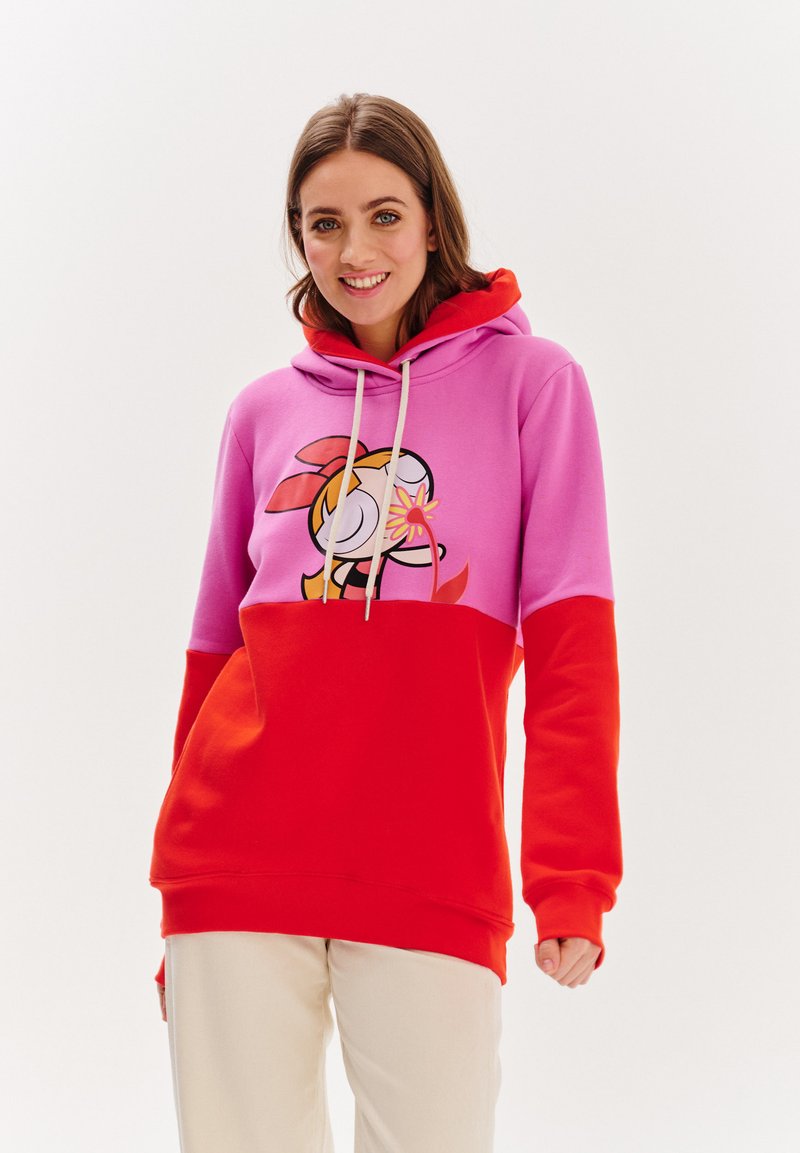 Mikina má design v růžových a červených barvách s blokovým vzorem, na kterém je grafika kreslené postavičky. Stahovací kapuce, žebrované manžety a měkká textilie.