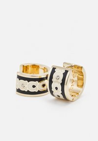 Guldtonade hoops med svart emalj, med ett dekorativt vitt mönster och små klara rhinestones. Släta metalliska och glänsande ytor.