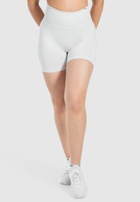 Lichtgrijze high-waisted fietsshorts van rekbaar materiaal met een geribde tailleband en boorden, ontworpen voor comfort en bewegingsvrijheid.