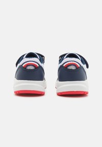 Scarpe da ginnastica blu navy e bianche con dettagli rossi. Presentano una tomaia in rete, una striscia in velcro e una suola in gomma testurizzata per una buona aderenza.