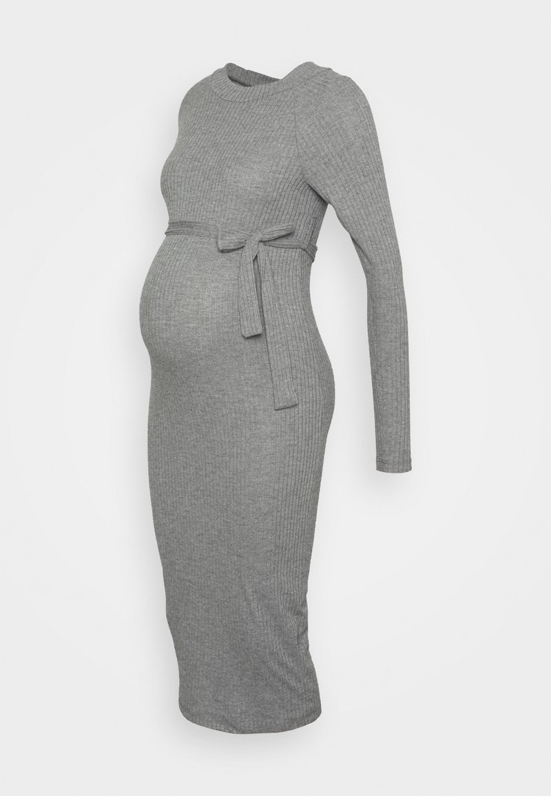 Robe de maternité grise moulante côtelée avec manches longues et nœud à la taille sur fond uni, vue de profil.