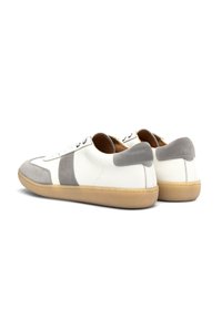 Białe skórzane sneakersy z szarymi zamszowymi akcentami, okrągły czubek, płaska gumowa podeszwa i sznurowany fason. Cechują się przeszyciami i minimalistycznym wyglądem.