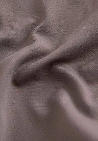 Tekstuuriga pehme kangas tuhmides mauve toonides, millel on peened sooned. Materjal näeb välja kerge ja selle pinnal on peened variatsioonid.