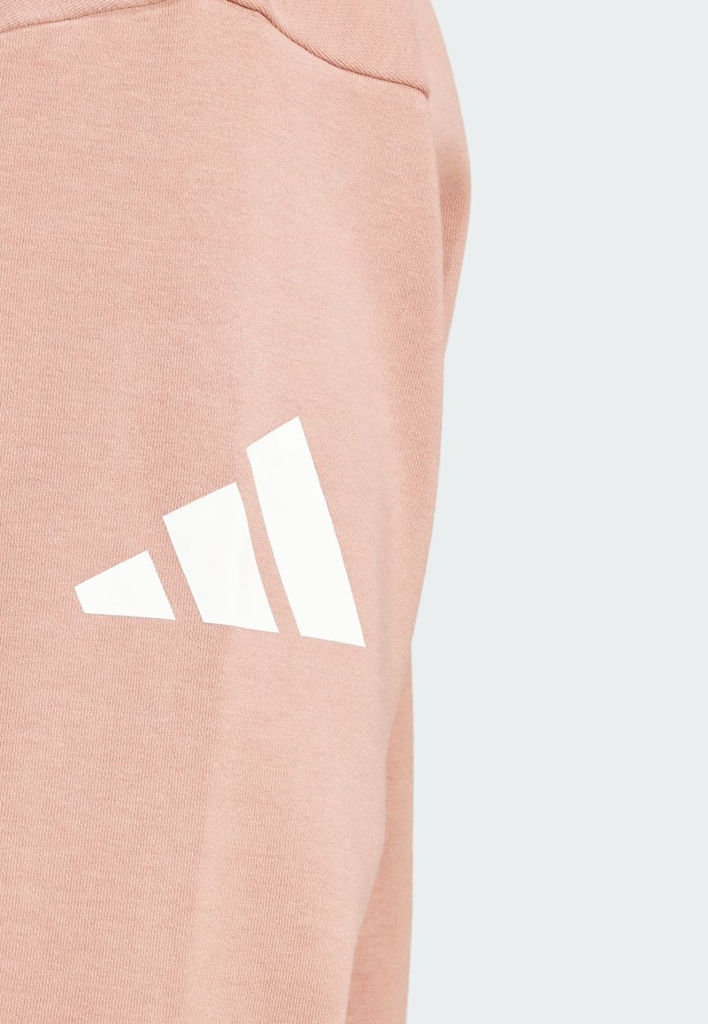 Pantalones de chándal de algodón rosa con el logotipo de tres rayas blancas en el costado, que cuentan con una textura suave y un corte contemporáneo.