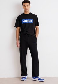 HUGO NANETTI - Pantalones deportivos - black
