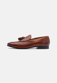 Brune skinnloafers med en jevn tekstur, med detaljer av dusk, lett oppadbuet tåform og en lav svart hæl.