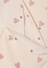 Hellrosa Fleece-Stoff mit kleinen, weichen rosa Herzen. Verfügt über Druckknöpfe entlang des Randes zum Schließen. Glatte Textur.