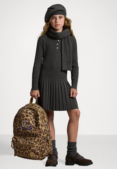 Vestido de punto acanalado gris con falda plisada, bufanda y boina a juego. Mochila de estampado de leopardo con parches. Zapatos marrones con calcetines grises acanalados.
