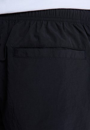 Czarne szorty z tkaniny z marszczoną talią i tylną kieszenią z prostokątnym otworem. Gładka tekstura, lekki materiał.