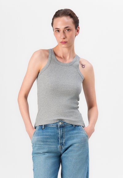Top de bumbac gri cu model rib și decolteu rotund, fără mâneci, purtat cu blugi denim ușori, de culoare albastră, cu buzunare frontale.