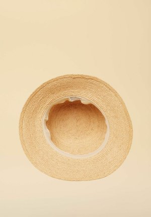 Pălărie de paie bej cu boruri largi și textură împletită, văzută de sus pe un fundal neutru simplu.