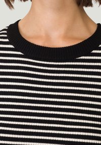 Czarnobiały sweter w paski, z dzianiny, z prążkowanym okrągłym dekoltem, z równomiernie rozmieszczonymi poziomymi paskami o miękkiej teksturze.