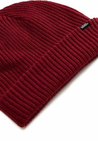 Red knitted beanie made from soft fabric, featuring a ribbed pattern and a folded cuff. Includes a small black Vans logo tag.