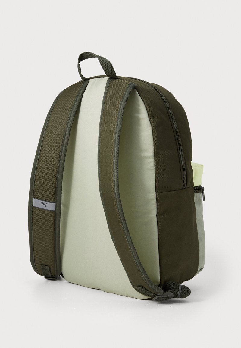 Sac à dos vert et vert clair avec des côtés rembourrés, fermeture zippée, bretelles ajustables et poignées supérieures. Il dispose d'une poche latérale pour le rangement.