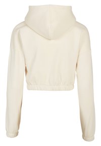 Sweat à capuche court couleur crème avec manches longues et poignets élastiques, vu de dos sur fond blanc.