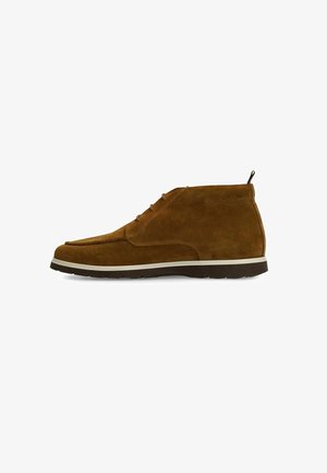 Brown suede ankle boots with a rounded toe, lace-up design, and contrasting white sole. Features a small pull tab at the heel.