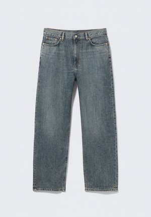 Jean en denim bleu clair à coupe ample, avec jambes droites, fermeture par boutons, cinq poches, présentant un léger délavage et des détails de coutures.