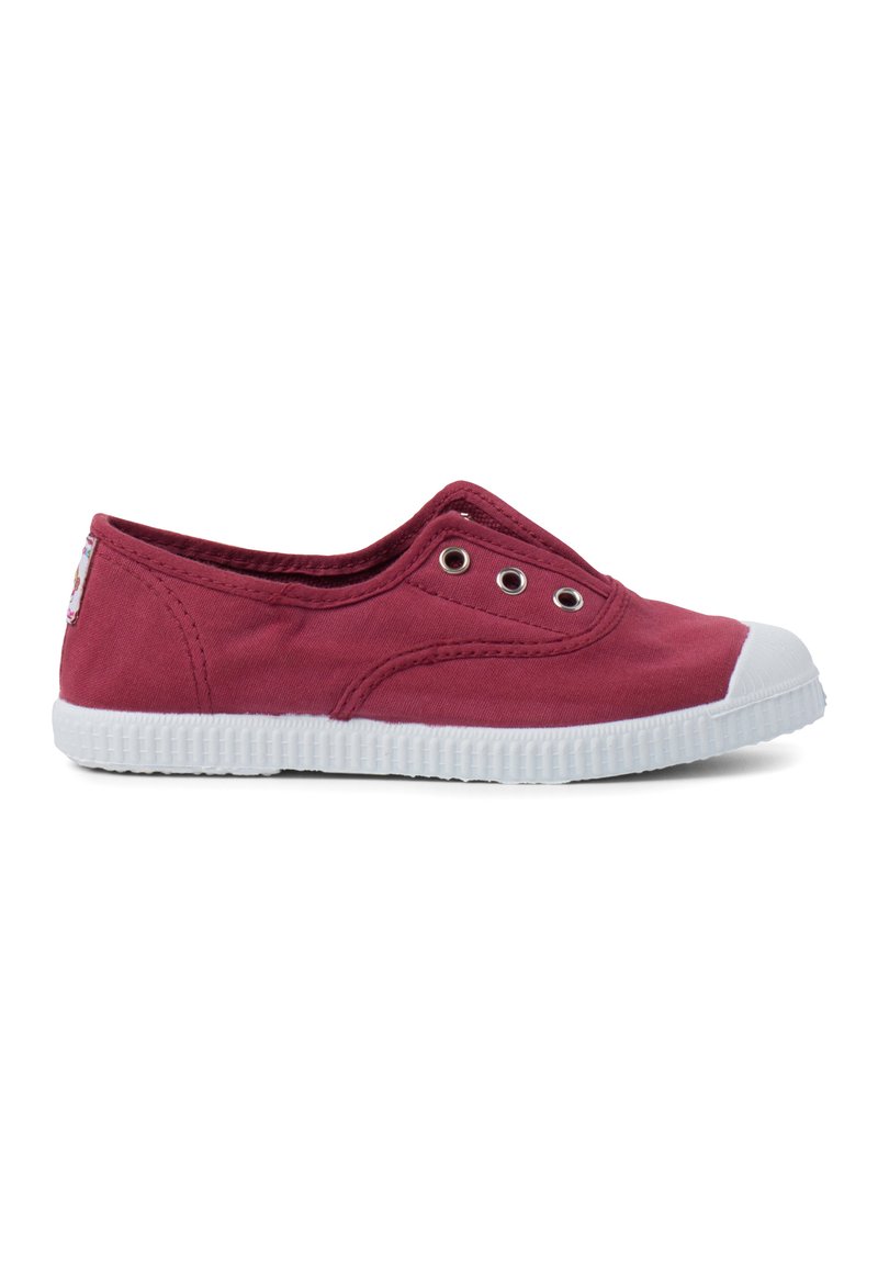 Chaussure slip-on en toile rouge avec un embout en caoutchouc blanc et une semelle texturée. Dotée de panneaux élastiques et d'œillets en métal pour la respirabilité.