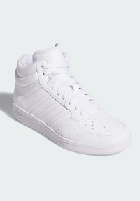 Bijela kožna visoka tenisica s perforiranim vrhom, teksturiranim panelima, ravnim vezicama i gumenim potplatom. Sadrži tri bočne pruge.