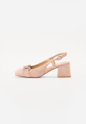 Zapato de ante rosa con talón descubierto, punta redonda, tacón grueso y un lazo decorativo con brillantes en la parte delantera. Tira ajustable con hebilla.