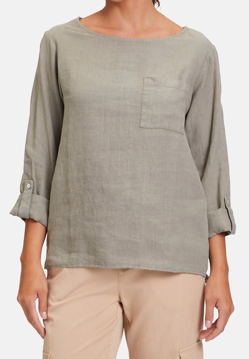 Ljusgrå linne skjorta med rund halsringning, enkel bröstficka och uppvikta ärmar. Mjuk textur och avslappnad passform.