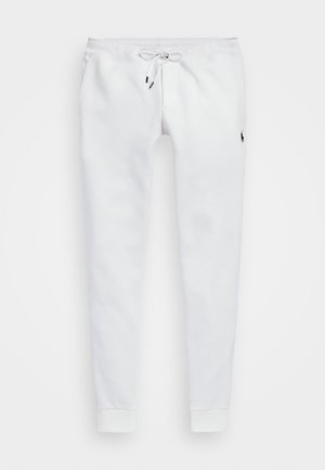 Hvite joggebukser laget av mykt stoff, med strikk i livet, sidelommer og ribbestrikkede mansjetter. Lite logo på låret.